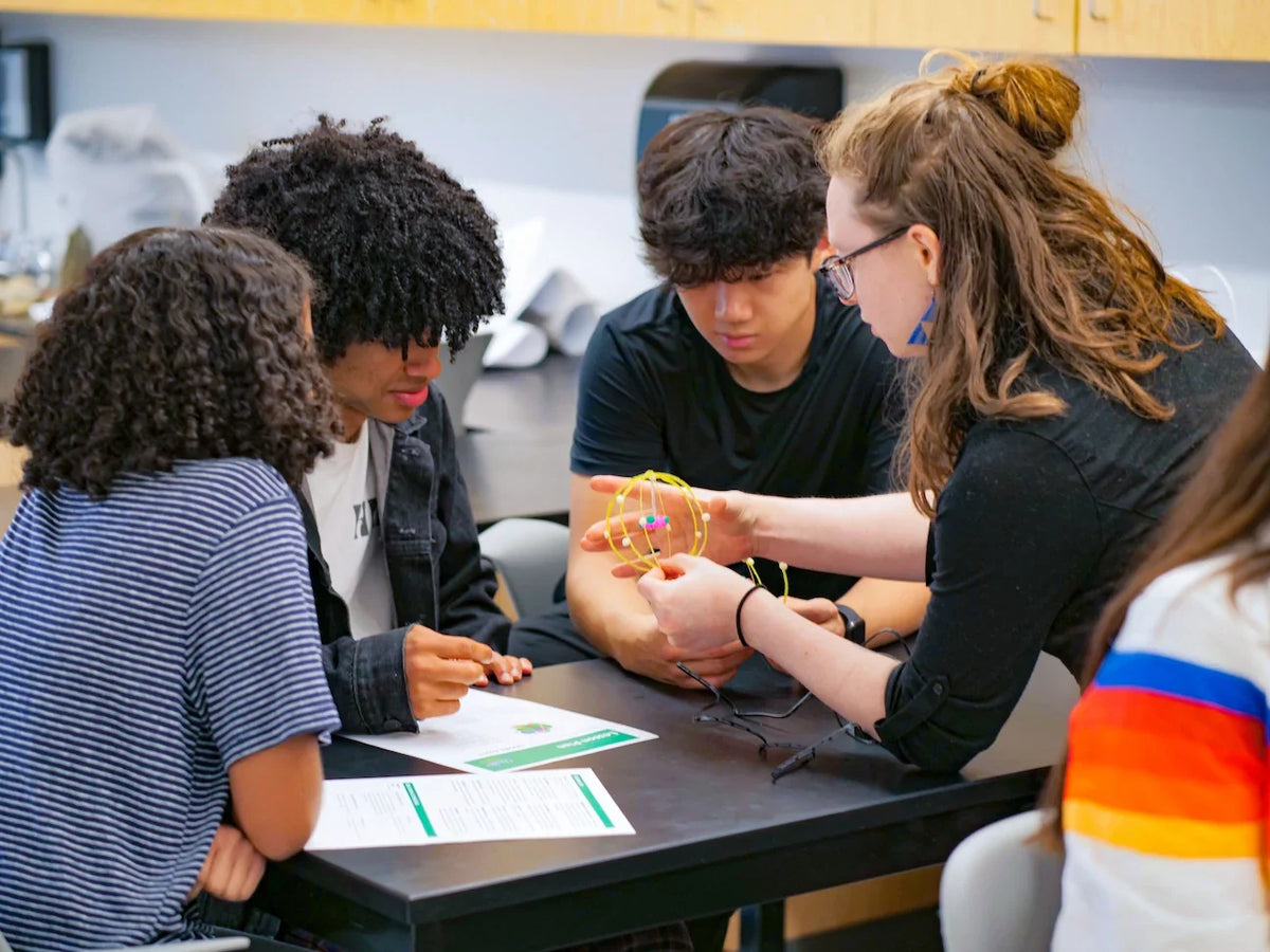 Group of students working together on a project with a 3D Printing pen in a classroom setting